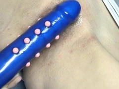 Skinny non-specific with small tits plays with a blue dildo